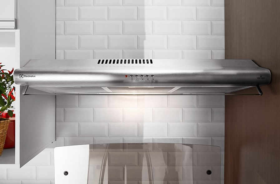 Uma grelha de depurador de ar sendo lavada embaixo da torneira