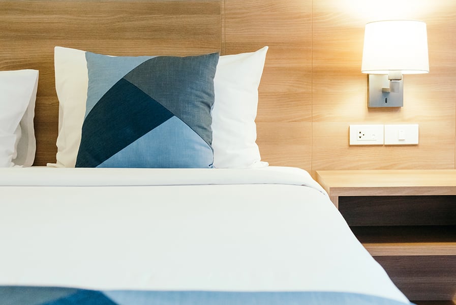 Cabeceira de madeira clara com criado-mudo acoplado