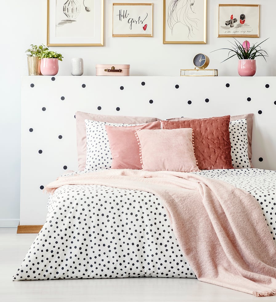 Cabeceira de cama criativa feita com adesivo de parede que combina com a colcha da cama