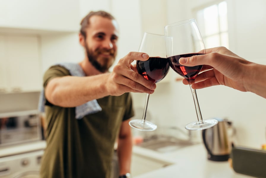 Amigos fazem um brinde com taças de vinho em casa