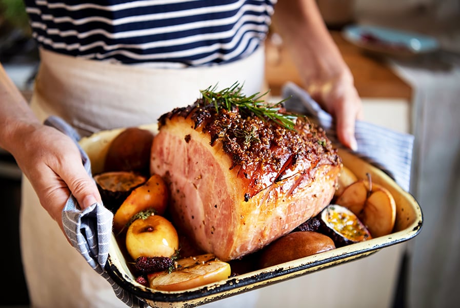Mãos segurando bandeja com receita gourmet.
