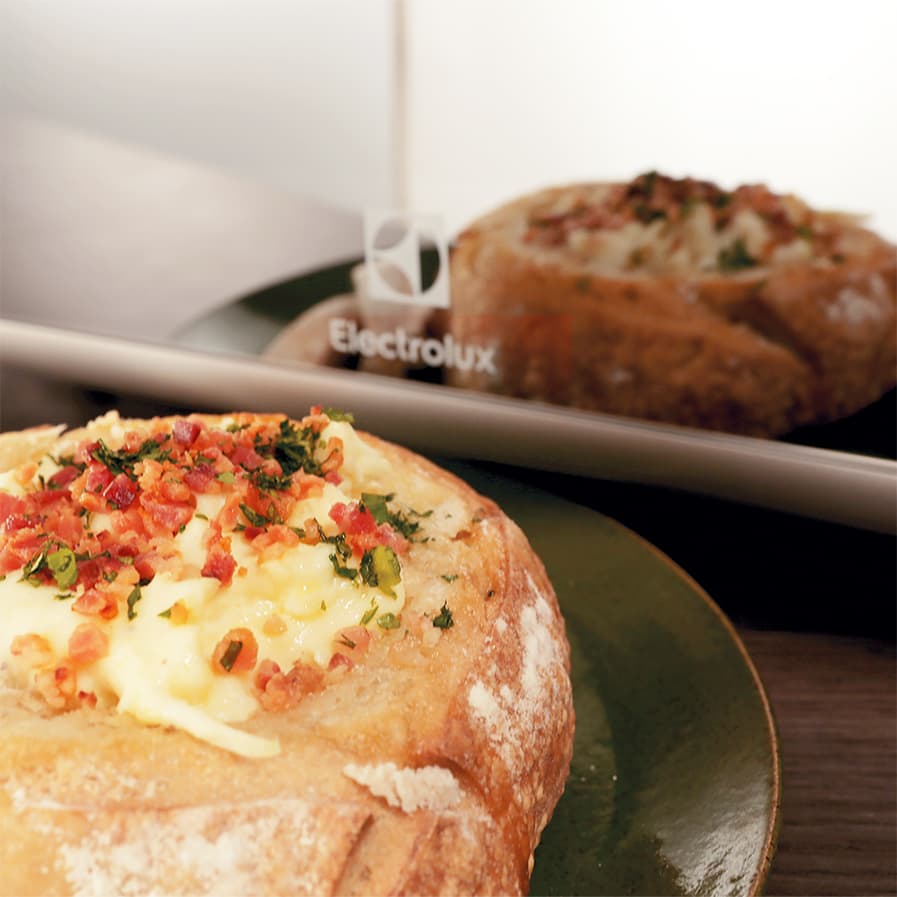 Pão recheado com queijo e bacon ao lado de micro-ondas Electrolux