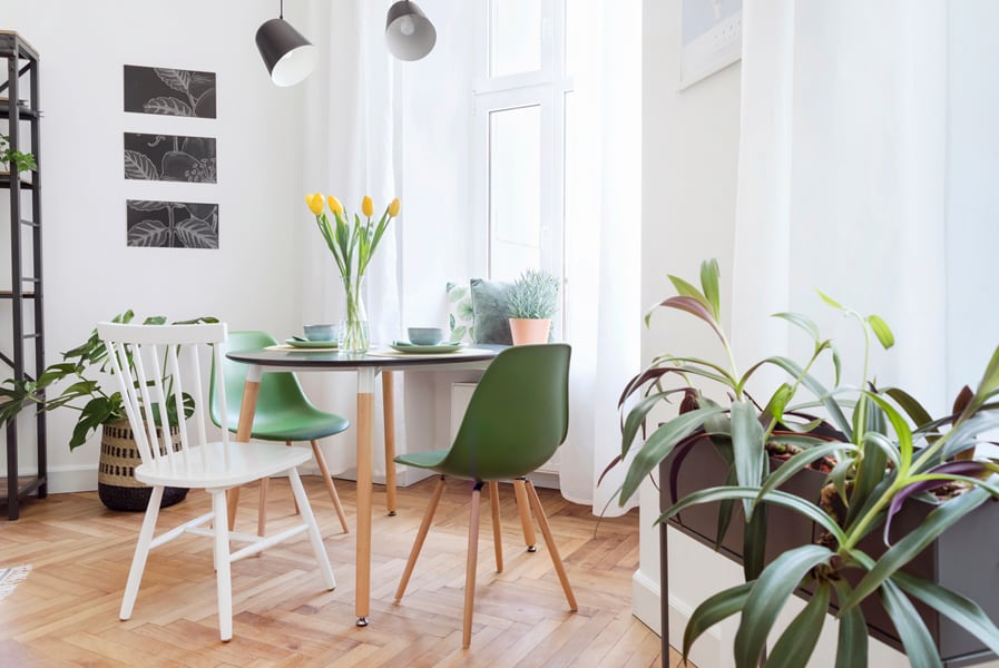 Mesa redonda com cadeiras verdes e branca na sala